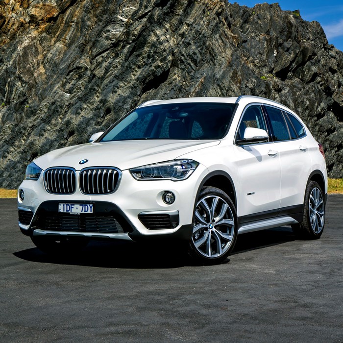 White BMW X1 F48 parked in front of a rocky mountain