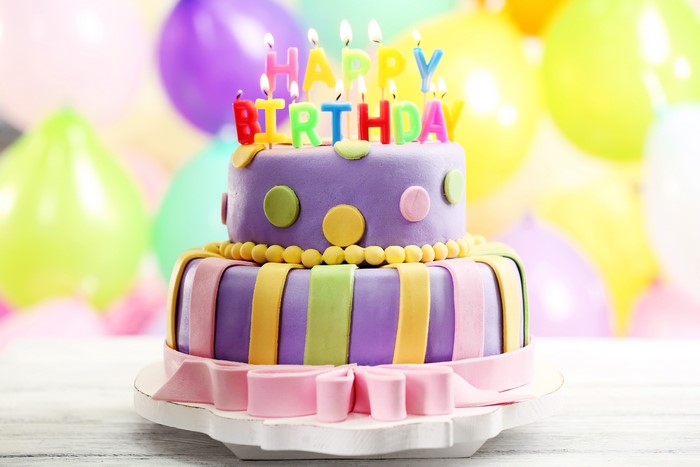 Birthday cake with candles and balloons