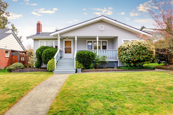 Light Gray House with Green Lawn and Shrubs