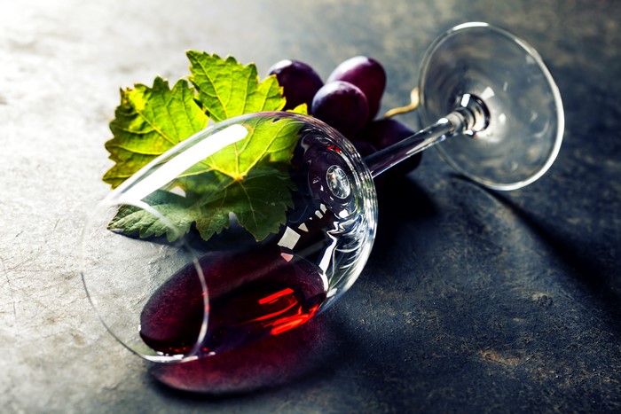 Wine glass with red wine and grapes