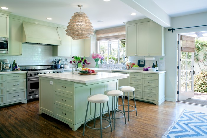 Kitchen with light green cabinets and island