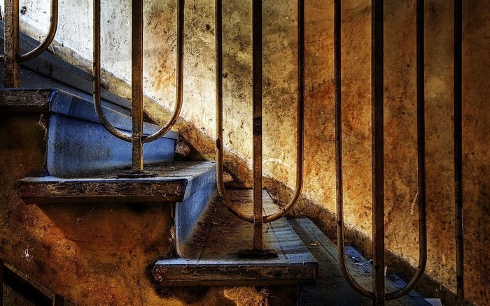 Closeup of old, weathered stairs with metal railing