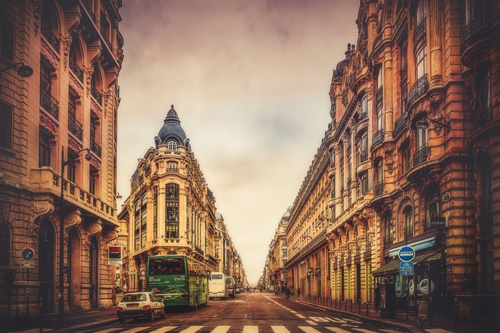 Street view of Parisian buildings with buses and cars