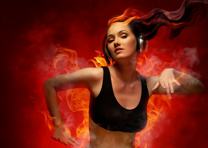 Woman with headphones surrounded by fire