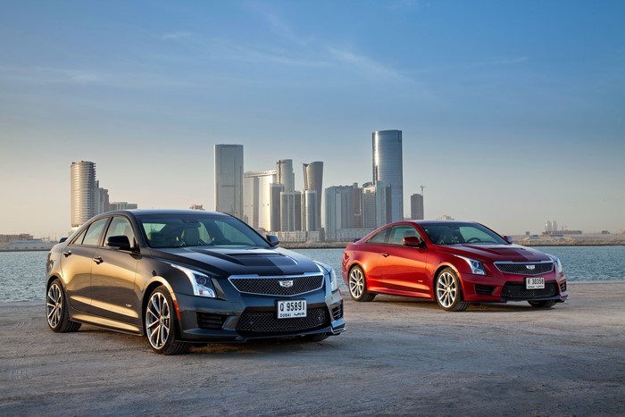 Two Cadillac ATS cars by the water with city skyline