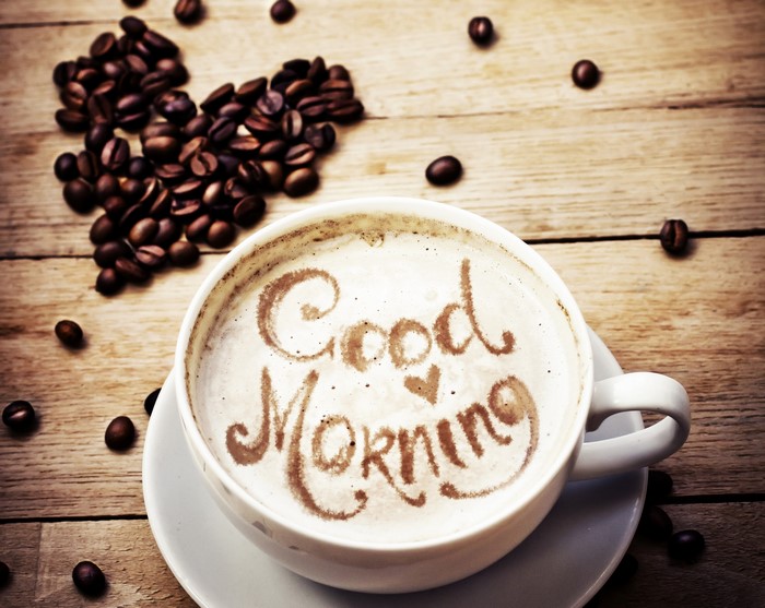 Coffee cup with "Good Morning" written in foam and coffee beans