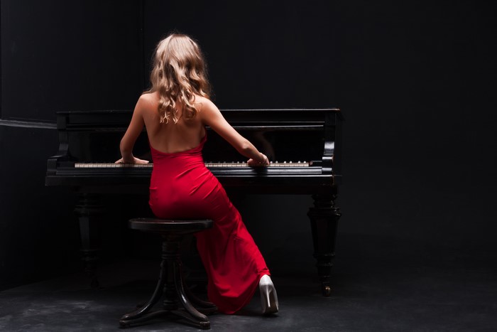 Woman in red dress playing piano