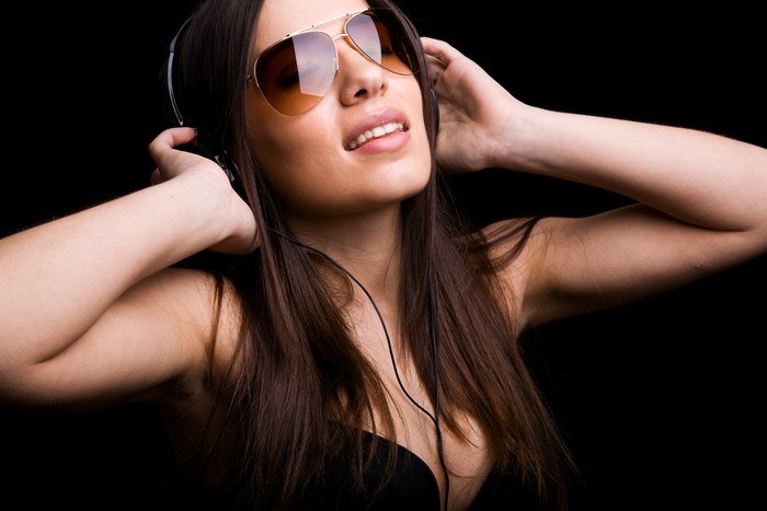 Brown haired woman with headphones and sunglasses