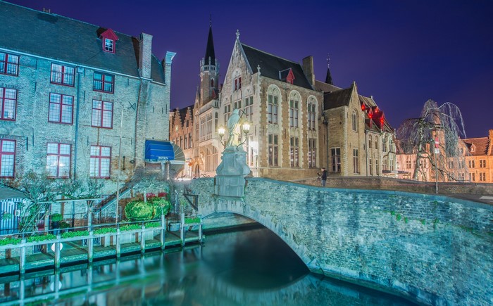 Canal bridge and buildings in Bruges, Belgium at night