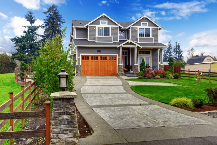 Luxury modern house with wooden garage door and green lawn