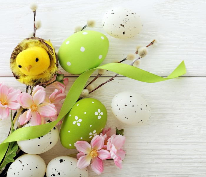Easter eggs and chick in a nest with flowers