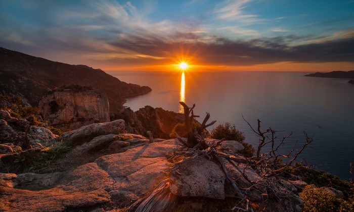 Sunset over the sea from a rocky coast