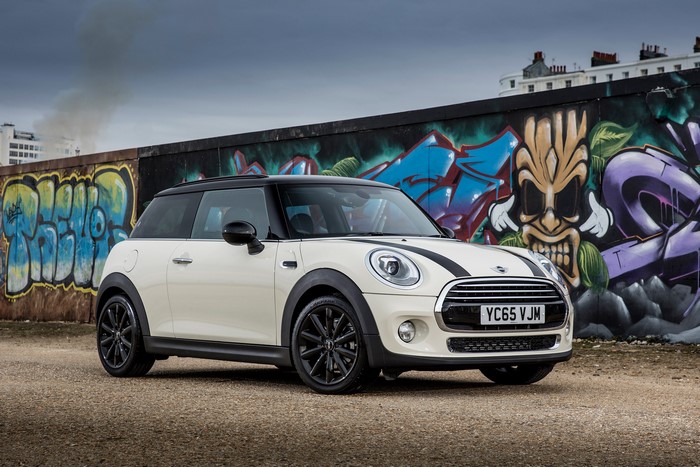 White Mini Cooper parked in front of graffiti wall