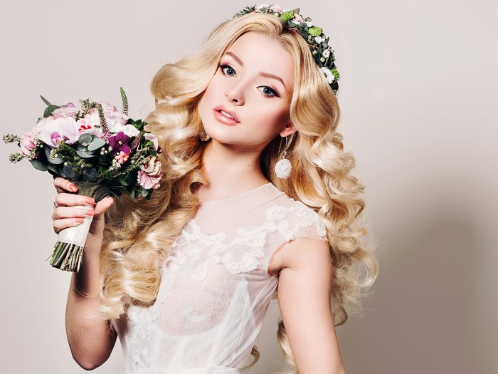 Blonde woman with flower crown holding a bouquet
