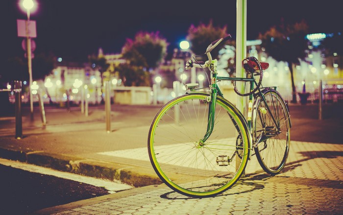 Bicycle parked on a street at night