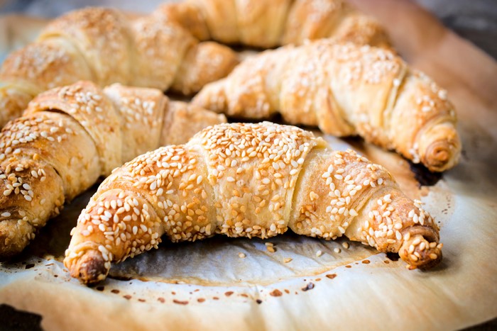 Croissants with sesame seeds on parchment paper