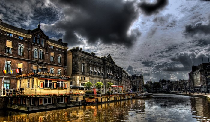 Amsterdam Canal with Buildings and Dark Clouds