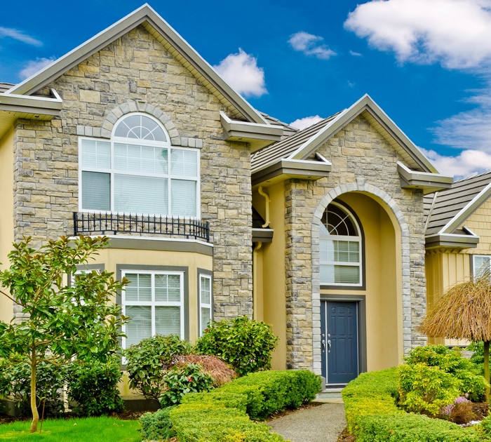 Luxury house with stone facade and manicured garden