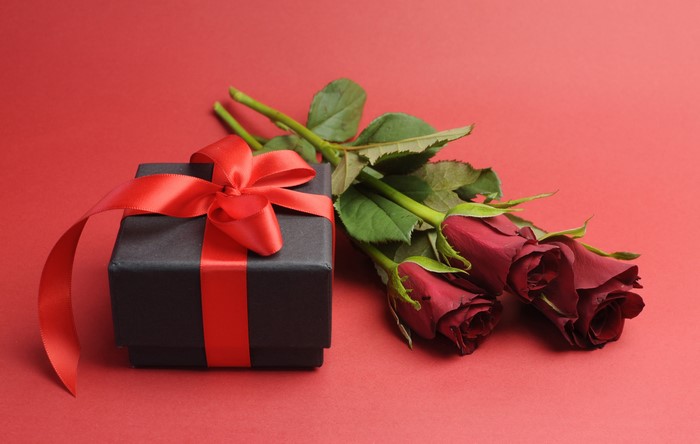 Black gift box with red ribbon and red roses