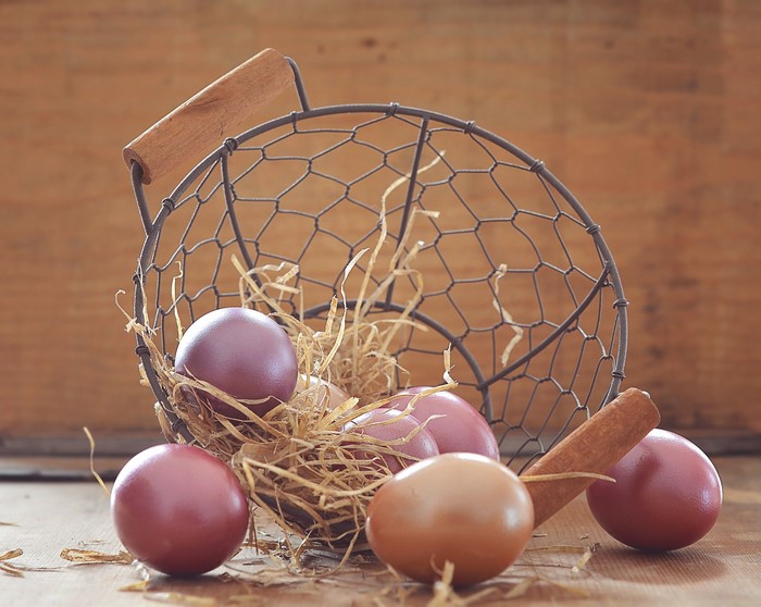 Easter eggs in a wire basket with straw