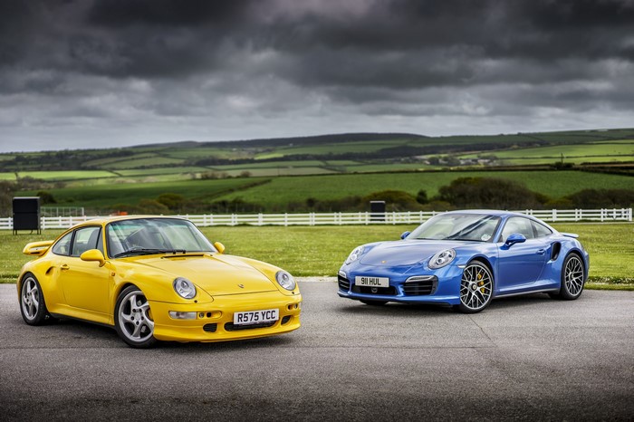 Two Porsche 911s, Yellow and Blue, on a Track