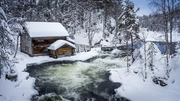 Wooden houses by a river in winter, Finland