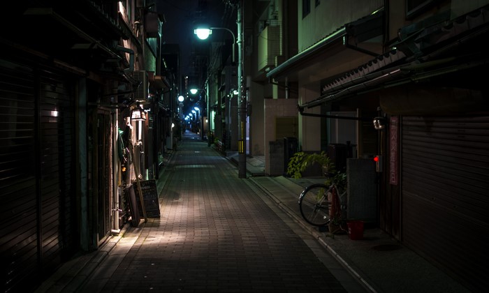Night alley in Japan with streetlights and a bicycle