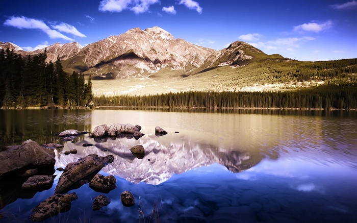 Mountain lake reflection with rocks in foreground