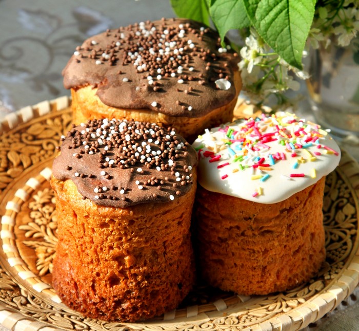Three Easter Kulich pastries on a decorative plate