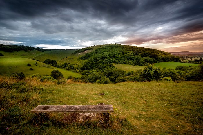 4K Scenery of Grasslands with a Bench and Cloudy Sky