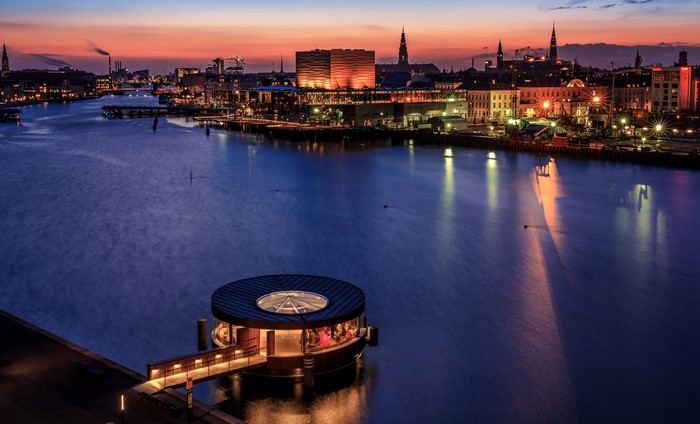 Copenhagen waterfront at dusk with illuminated buildings