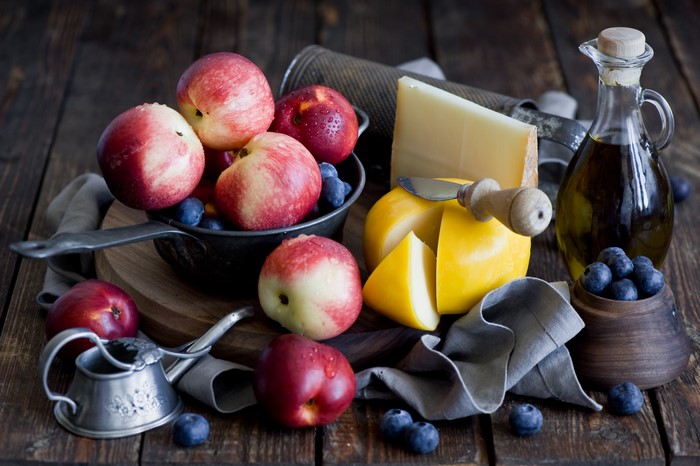 Nectarines, blueberries, cheese, and olive oil on a wooden table