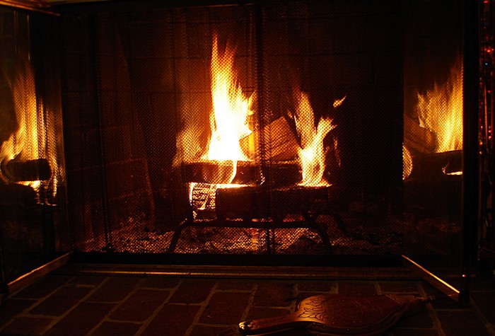 Fireplace with burning logs and bellows