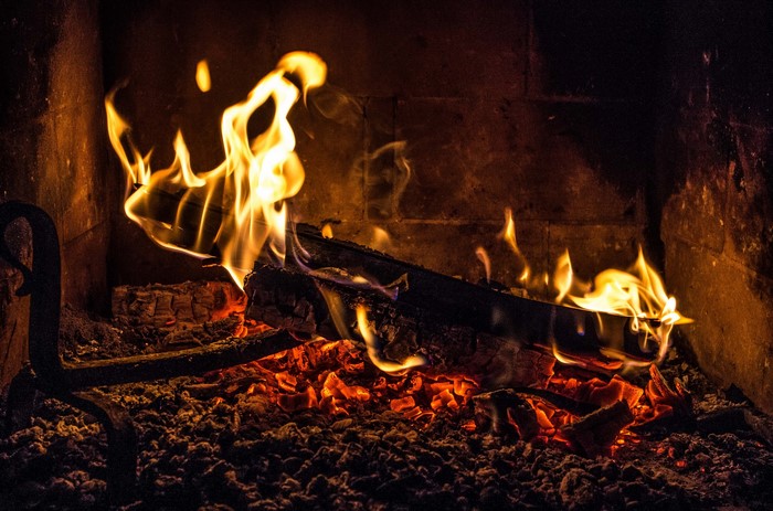 Fire burning in a fireplace with glowing embers