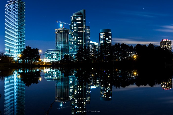 Cityscape with skyscrapers reflected in a pond at night