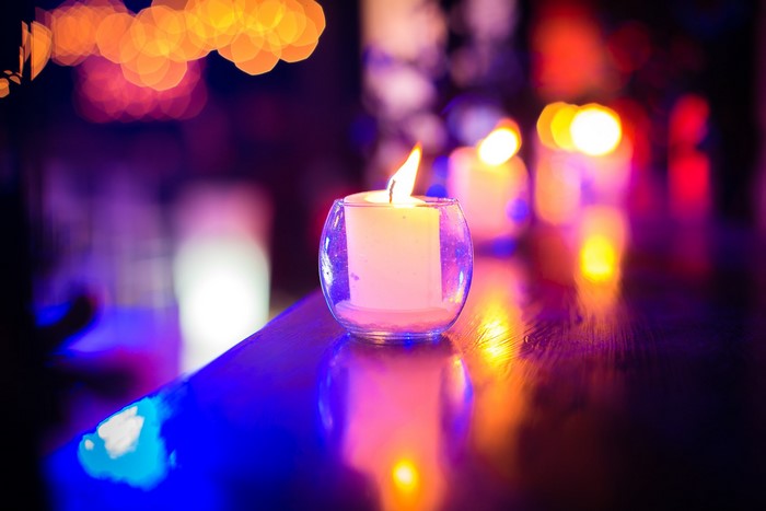 Candles in glass holders with bokeh lights