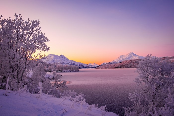 Snowy Mountains and Frozen Lake at Sunset in Norway
