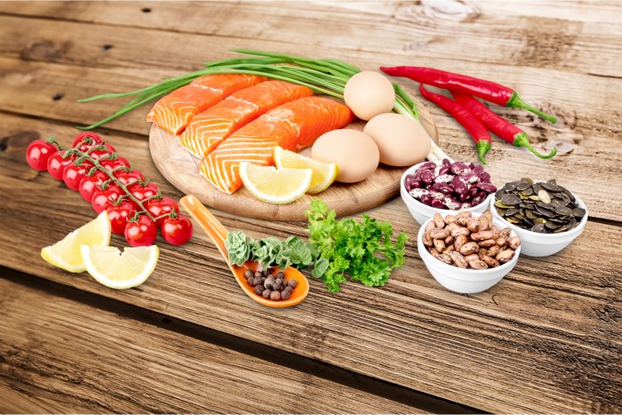 Salmon, Eggs, Vegetables, and Beans on a Wooden Table