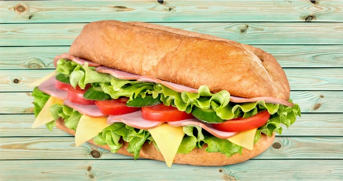 Sandwich with ham, cheese, lettuce, tomato, and cucumber