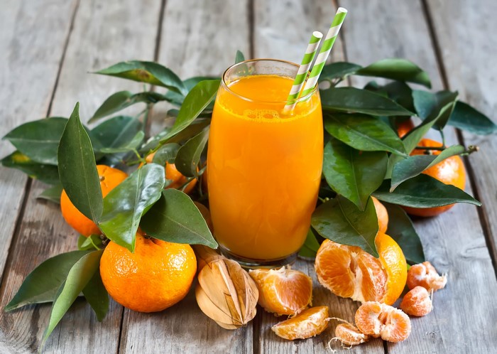 Orange juice with tangerines and leaves