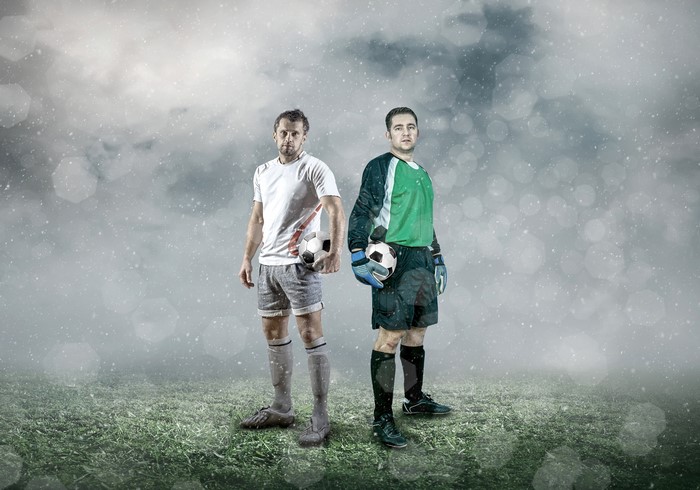 Two male football players with soccer balls