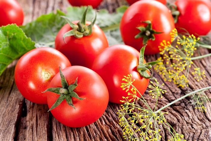 Tomatoes and Dill on a Wooden Surface