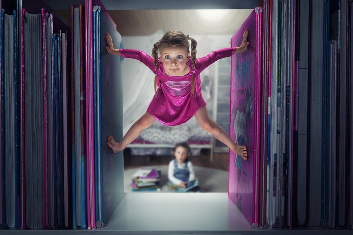 Little girls in dresses between books