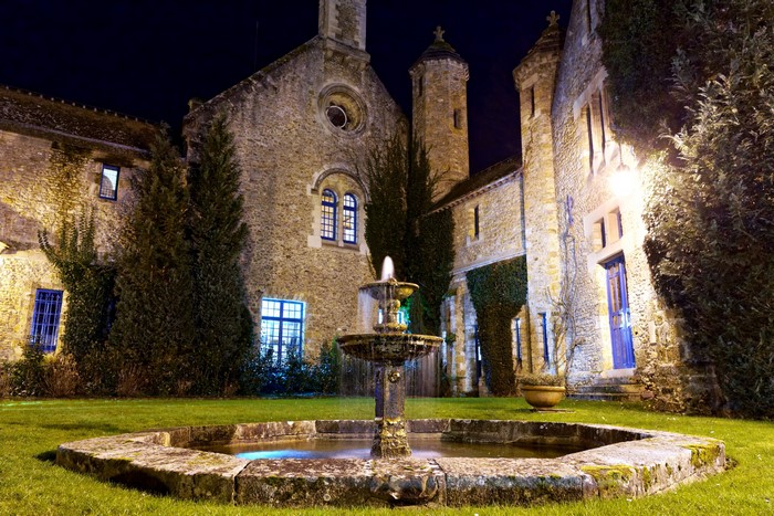 Fountain in courtyard of Vaux de Cernay at night
