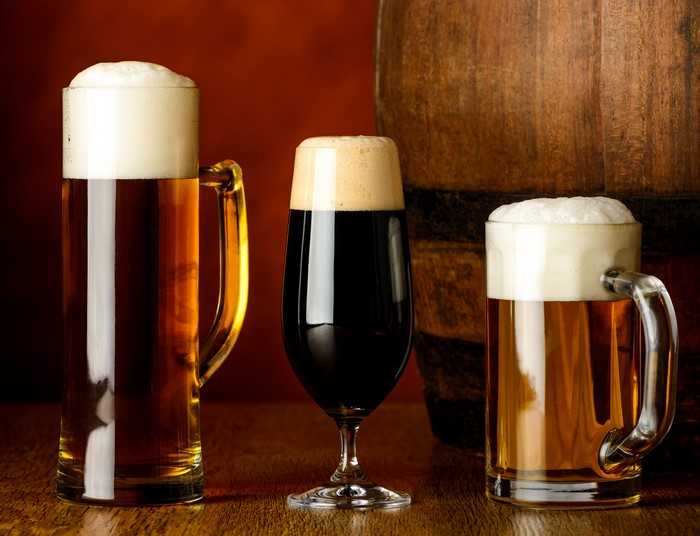 Three beers in mugs and a barrel