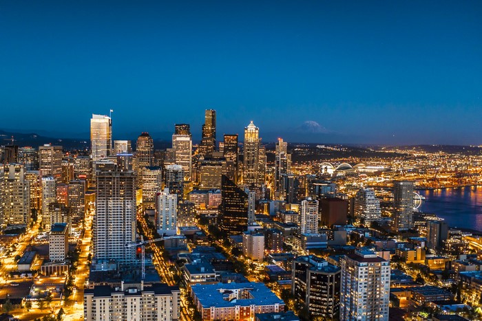 Seattle skyline at night with Mount Rainier in the distance