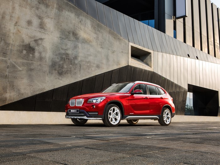 Red 2012-2016 BMW X1 xDrive28i parked near a modern building