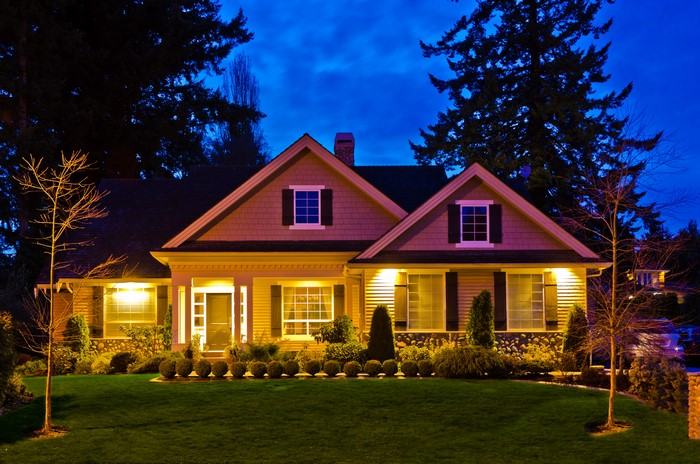 House at night with illuminated lawn and trees