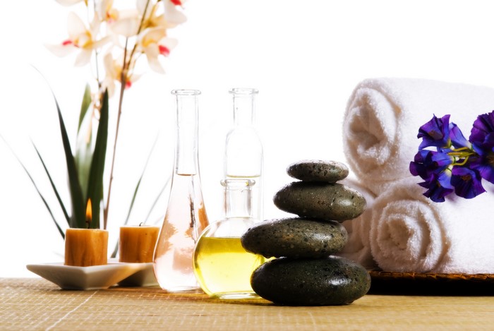 Spa setting with candles, stones, towels, and flowers