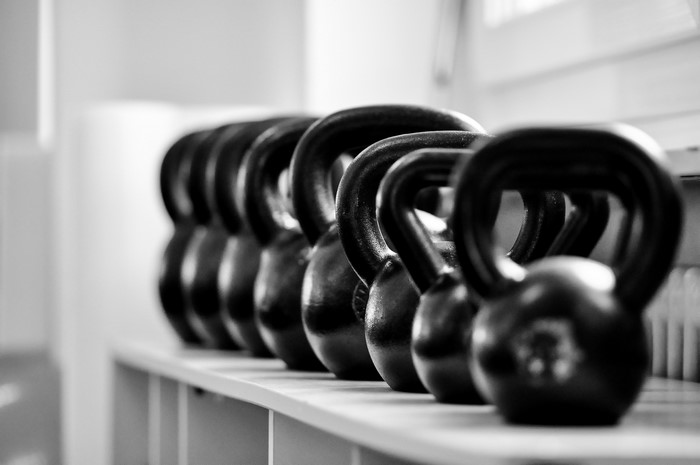 Row of black kettlebells on a shelf